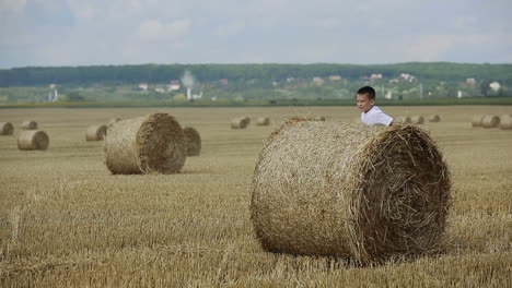 child on a field against straw. happy child on a field with bales harvest