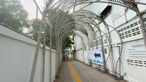 a narrow path with metal arches overhead