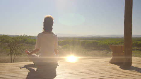 animation of light spots over caucasian woman practicing yoga and meditating