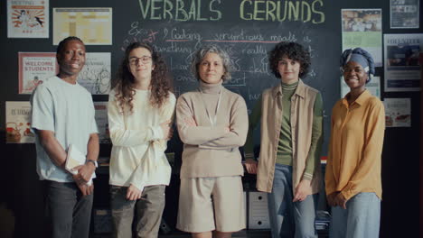 group portrait of diverse students and english teacher in college classroom