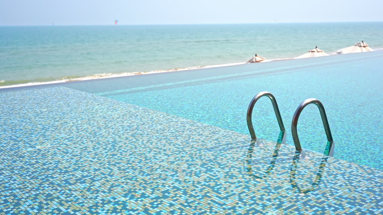 금속 난간이 있는 빈 해안가 인피니티 풀 입구