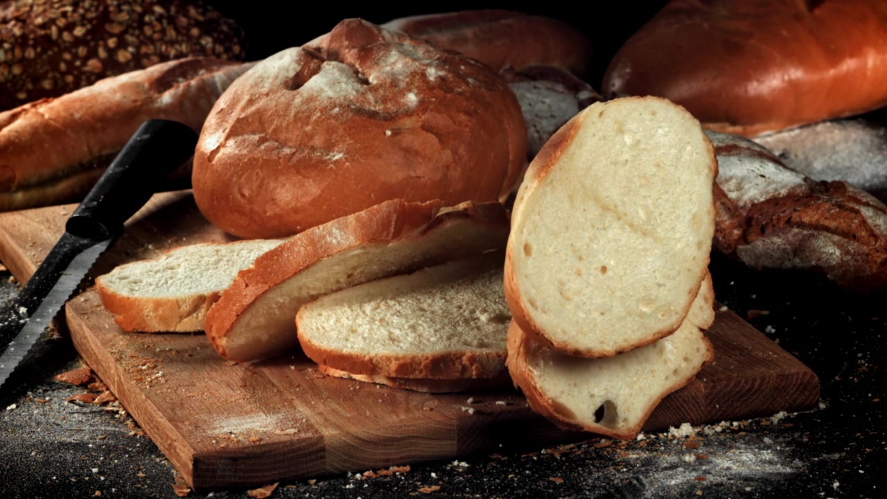 Pane a fette che cade al rallentatore su un tagliere di legno