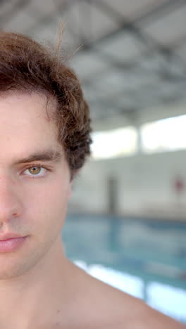 vertical video: swimmer posing confidently at indoor pool, preparing for swim training session