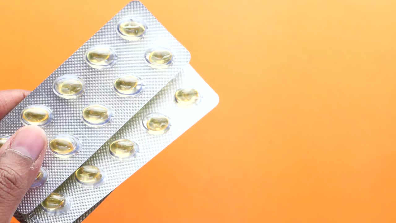 mano con un blister de cápsulas