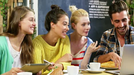 group of friends using laptop while having coffee