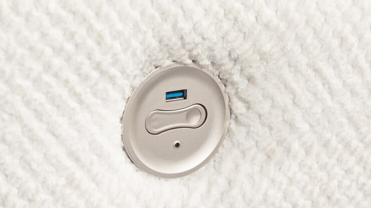 Camera slowly zooms on metal USB panel embedded in fluffy sofa side