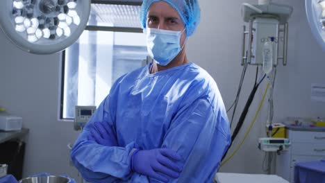 Portrait-of-male-caucasian-surgeon-wearing-face-mask-and-scrubs-in-hospital