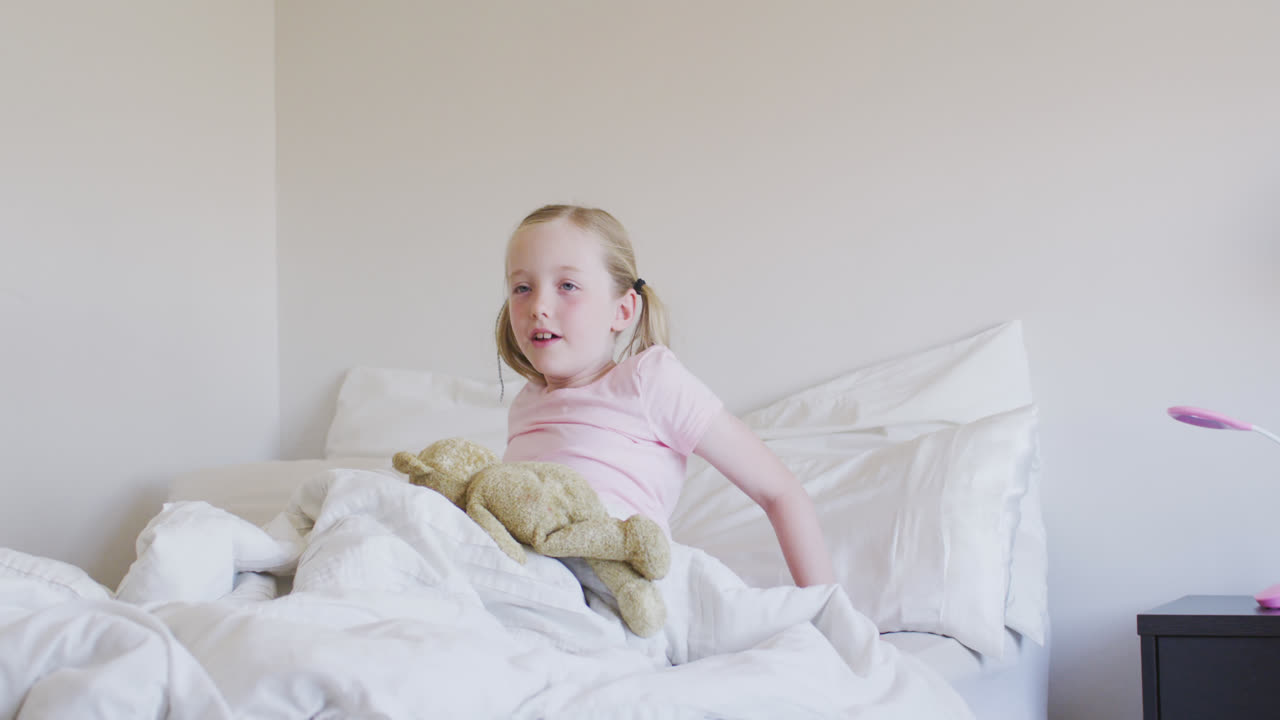 침대에서 깨어나는 백인 소녀의 측면 시각