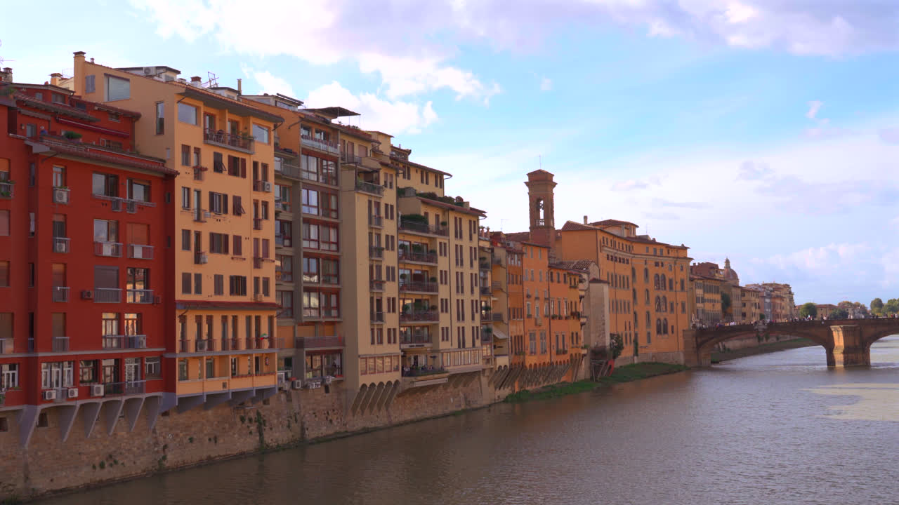 Panoramica ampia del fiume Arno a Firenze con ponti e facciate rinascimentali sotto la luce del sole pomeridiano