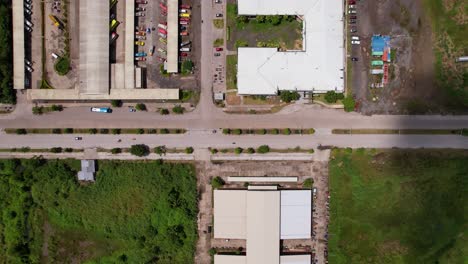 los coches y los autobuses llegan a una terminal de autobuses local con sombras de nubes que se pueden ver