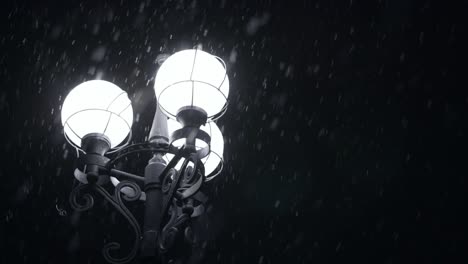 Street-lamp-glowing-in-snowy-night.-Close-up-street-light-in-winter-snowflakes