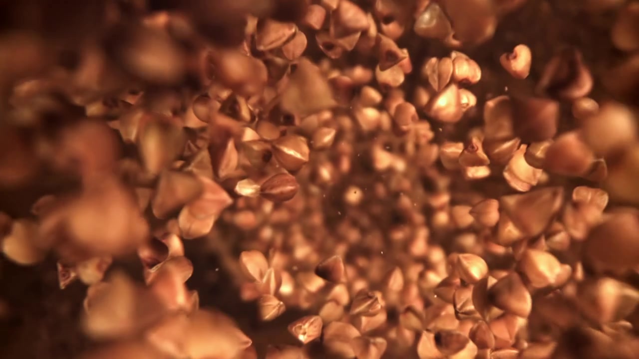Primo piano di grani di grano saraceno che cadono al rallentatore