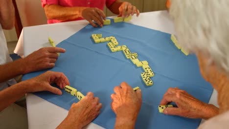 amigos mayores jugando al dominó