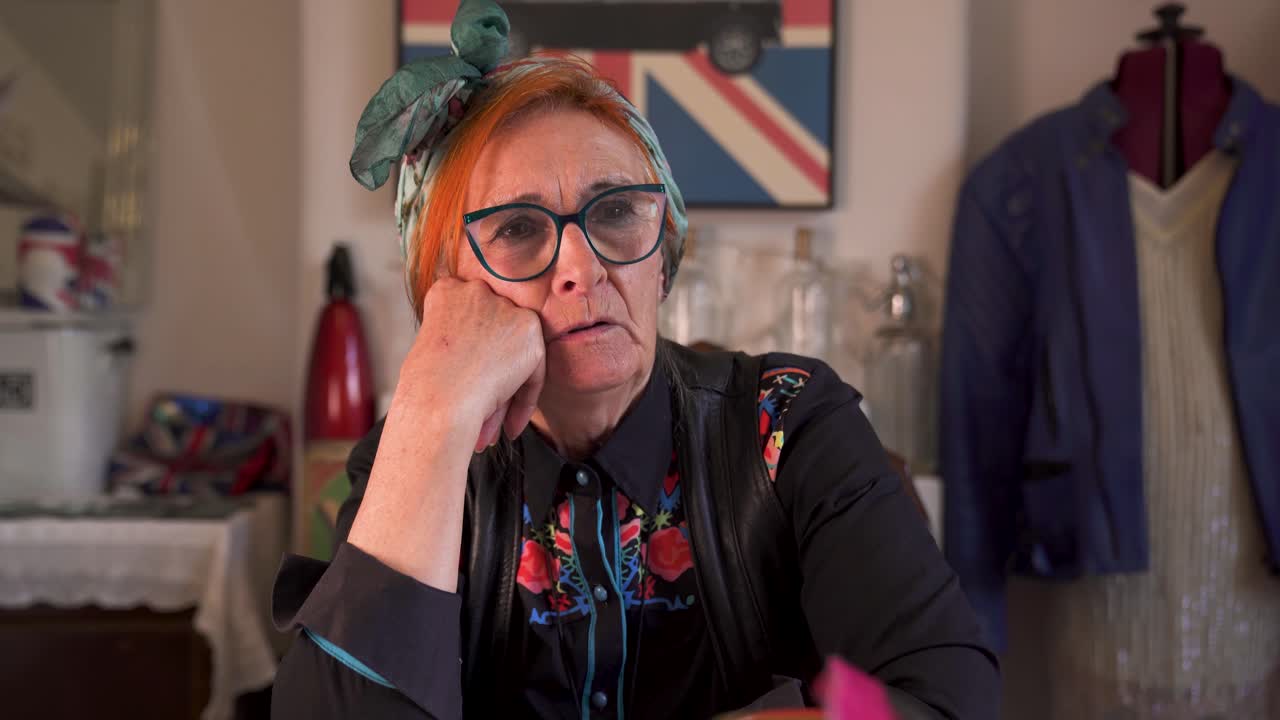 An modern, trendy older lady sitting talking in a home setting