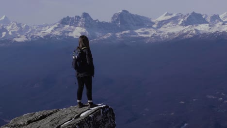 staring out into the vast landscape lined with a snow-tipped mountain ridge. this view is from the whistlers summit in jasper alberta.