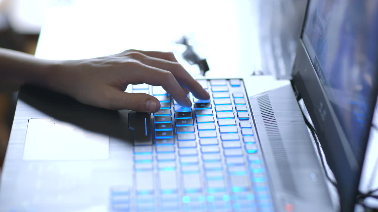 Young boy's hand on a laptop keyboard playing video games closeup on hand and keyboard