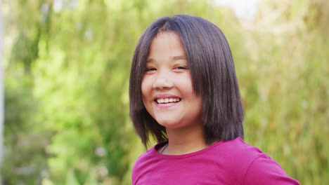 Video-of-portrait-of-happy-asian-girl-posing-in-garden