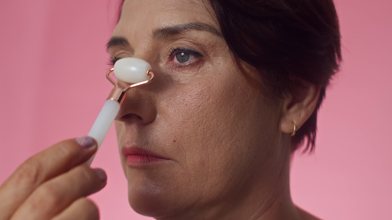 Woman Doing Facial Rejuvenation Roller Massage