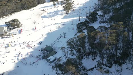 Aerial-view-of-a-busy-alpine-snow-resort-with-many-winter-activities