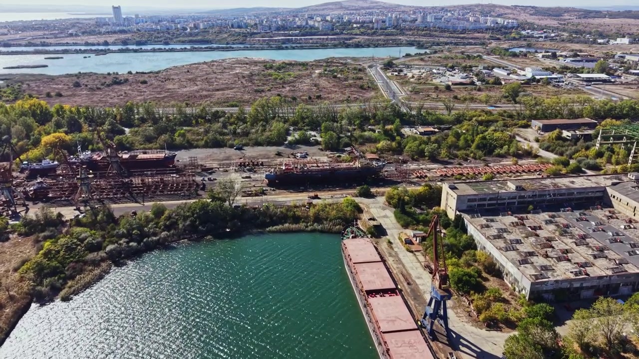 Vista di un'area industriale vicino a un fiume con edifici abbandonati e barche durante le ore diurne