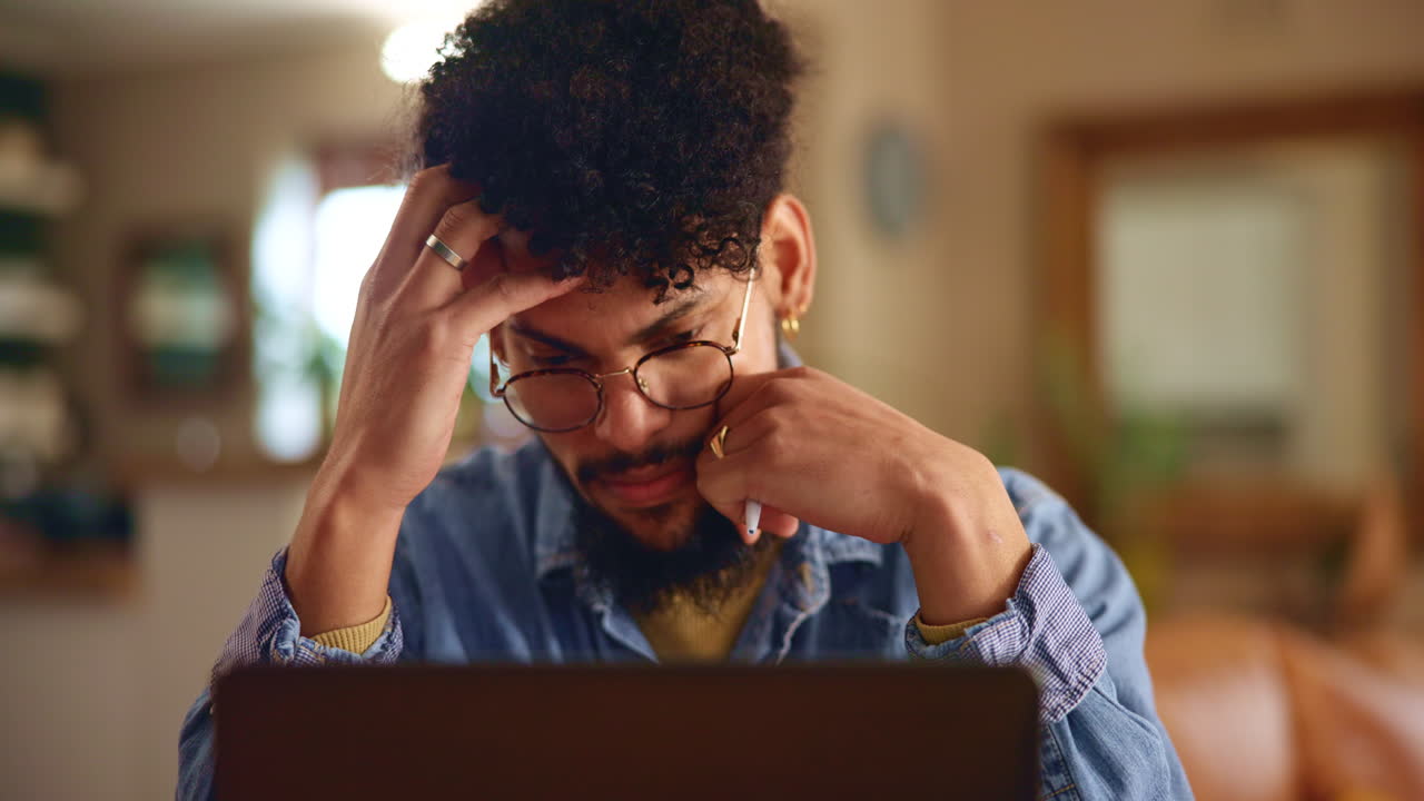 Man looking frustrated while working on his laptop