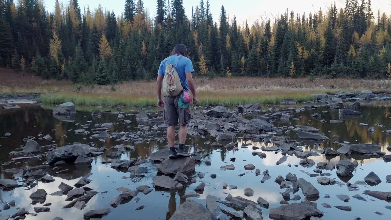 kananaskis alberta canada 주위를 둘러보고 있는 연못 바위에서 균형을 잡고 있는 등산객