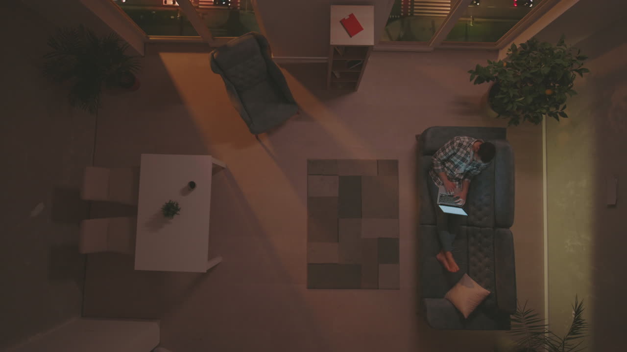 집에서 저녁에 노트북에서 일하는 남자