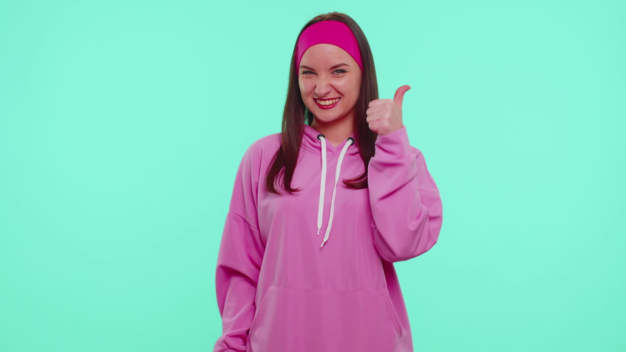 십대 소녀는 엄지손가락을 들고 동의하거나 긍정적 인 답변을합니다. 광고를 추천합니다. 좋아합니다.