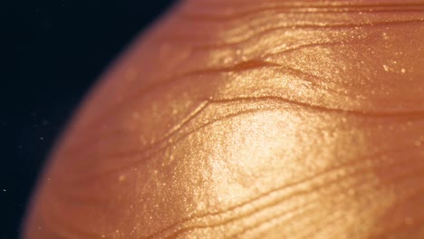 golden ink particles flows in water as caramel on the lollipop