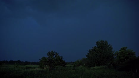 lightning strikes on the dark sky. stormy sky with lightning flashing over green nature in the evening. dark blue sky becomes light with a lightning splash in summer.
