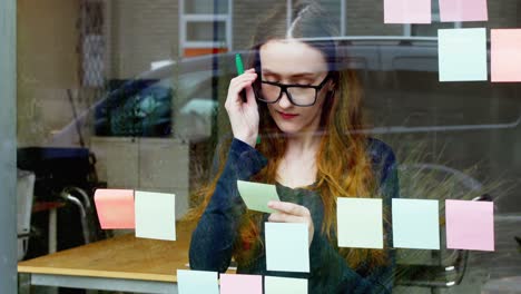 ejecutivo de negocios leyendo una nota adhesiva mientras toma una taza de café