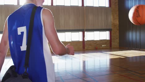 Diverse-male-basketball-team-and-coach-practice-dribbling-ball