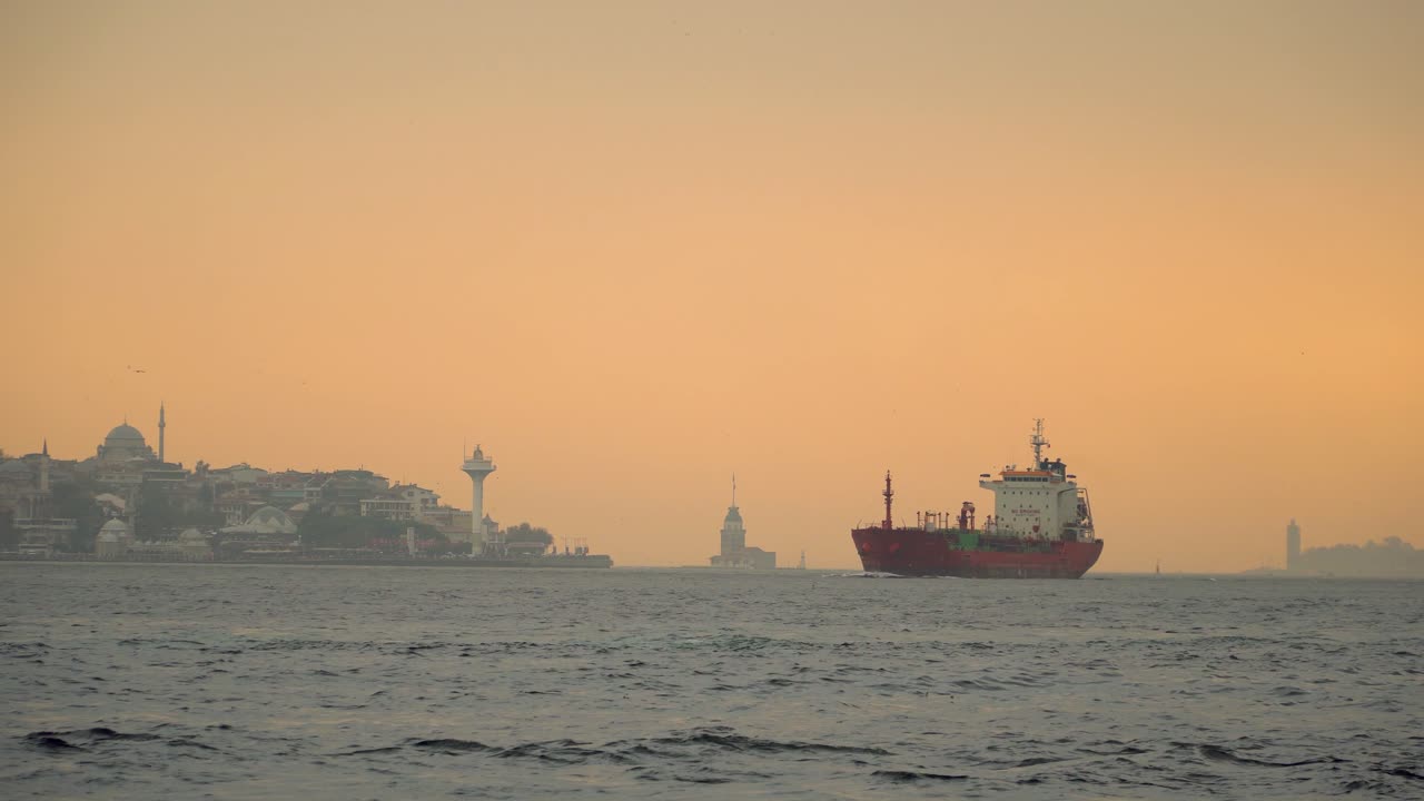 panorama de estambul del barco de contenedores en el bósforo durante la puesta de sol con la torre de la doncella