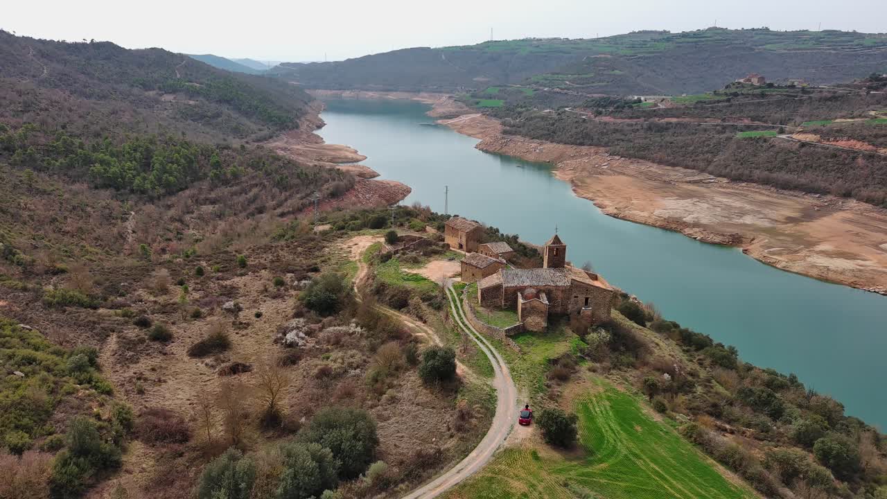 Ripresa aerea in allontanamento del complesso di torri di Rialb con fiume e paesaggio circostante, Lleida in Spagna