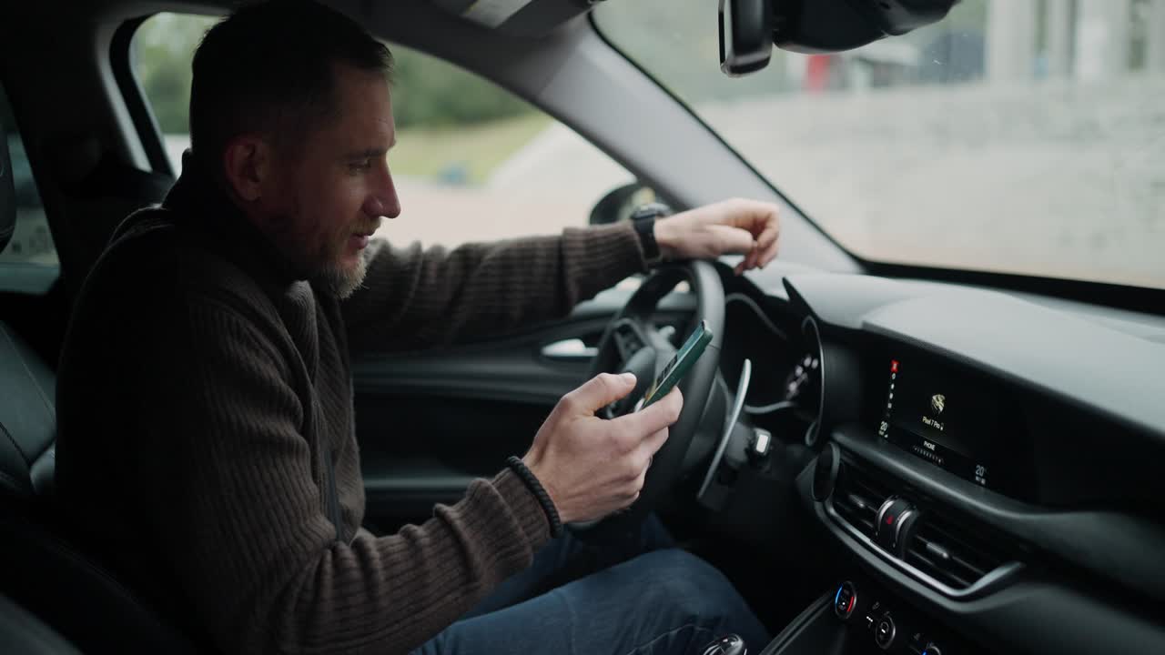 hombre conduciendo un coche y usando un teléfono inteligente