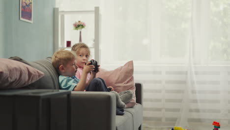 Cute-toddler-learns-to-use-gaming-console-with-elder-sister