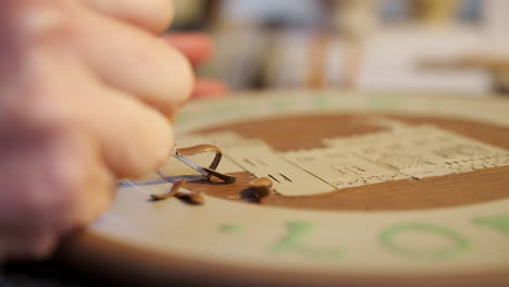 Close-Up-Of-Male-Potter-Carving-Picture-Onto-Clay-Plaque-For-House-Sign-In-Ceramics-Studio