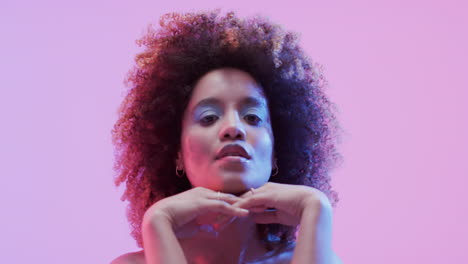 mujer biracial con cabello oscuro en luz azul y rosa, cámara lenta
