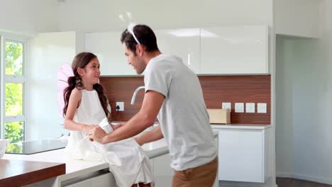 father and masked daughter in kitchen