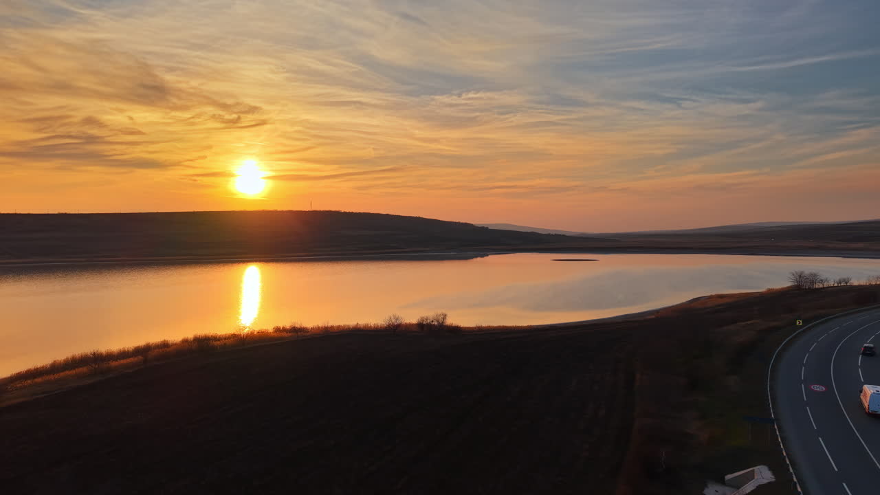 Aerial drone view of a highway near a lake in Moldova at sunset
