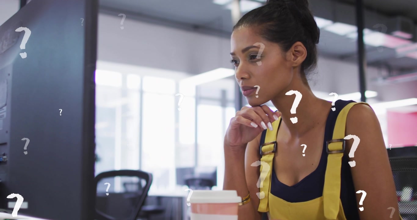 Animation of question mark symbols over thoughtful woman using computer at office