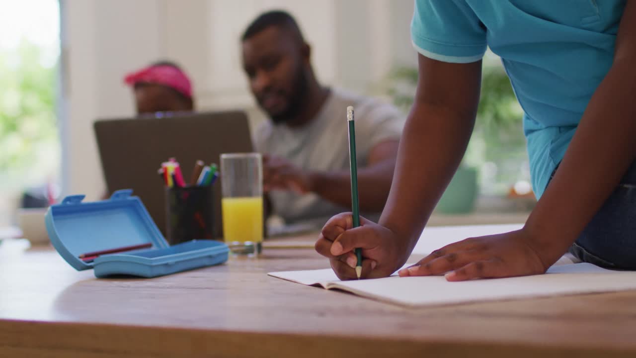 Mid section of african american boy doing homework at home