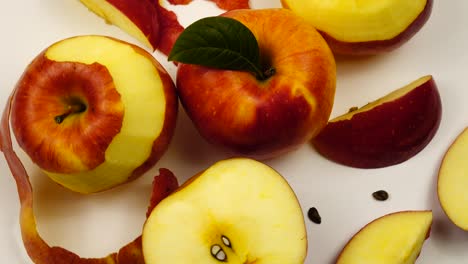 ripe fresh apples and  slices of apple  lie on a white table