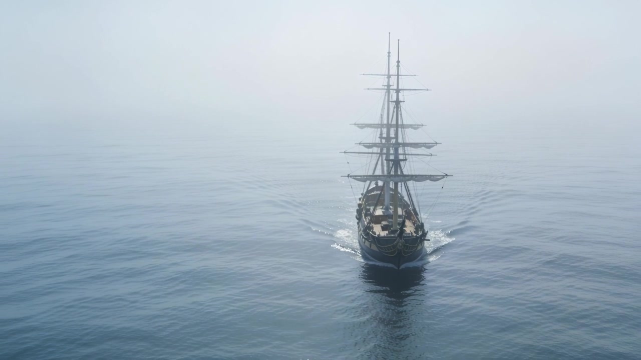 Kamera filmt ein Dreimast-Segelschiff, das sich auf offener See auf die Kamera zubewegt und gereffte Segel zeigt.