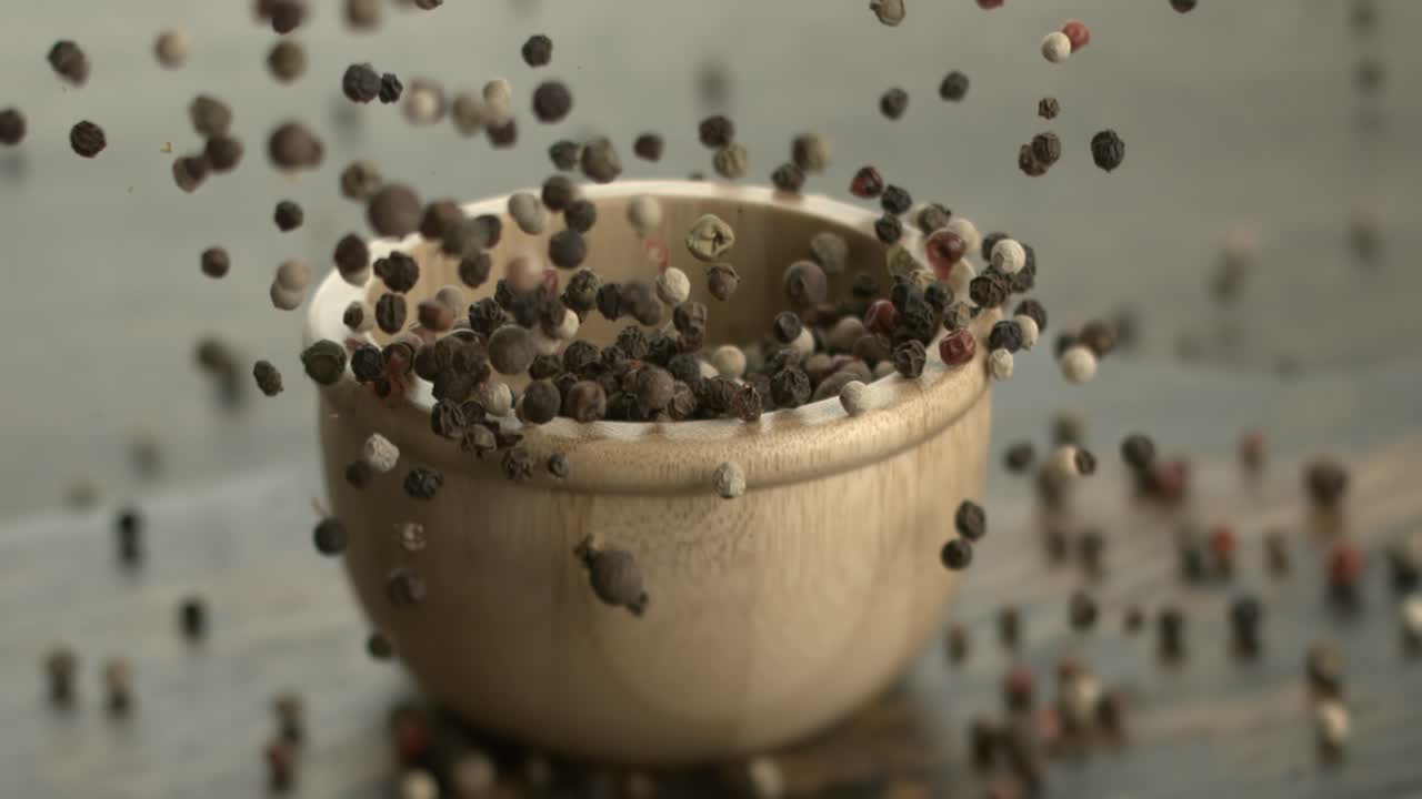 Mixed peppercorns in a super slow motion. Dry mix peppercorns close up.