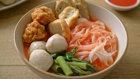 small flat rice noodles with fish balls and shrimp balls in pink soup, yen ta four or yen ta fo - asian food style