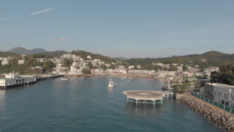 Aerial-view-of-a-helipad-just-outside-of-a-coastal-village-located-in-a-beautiful-ocean-bay