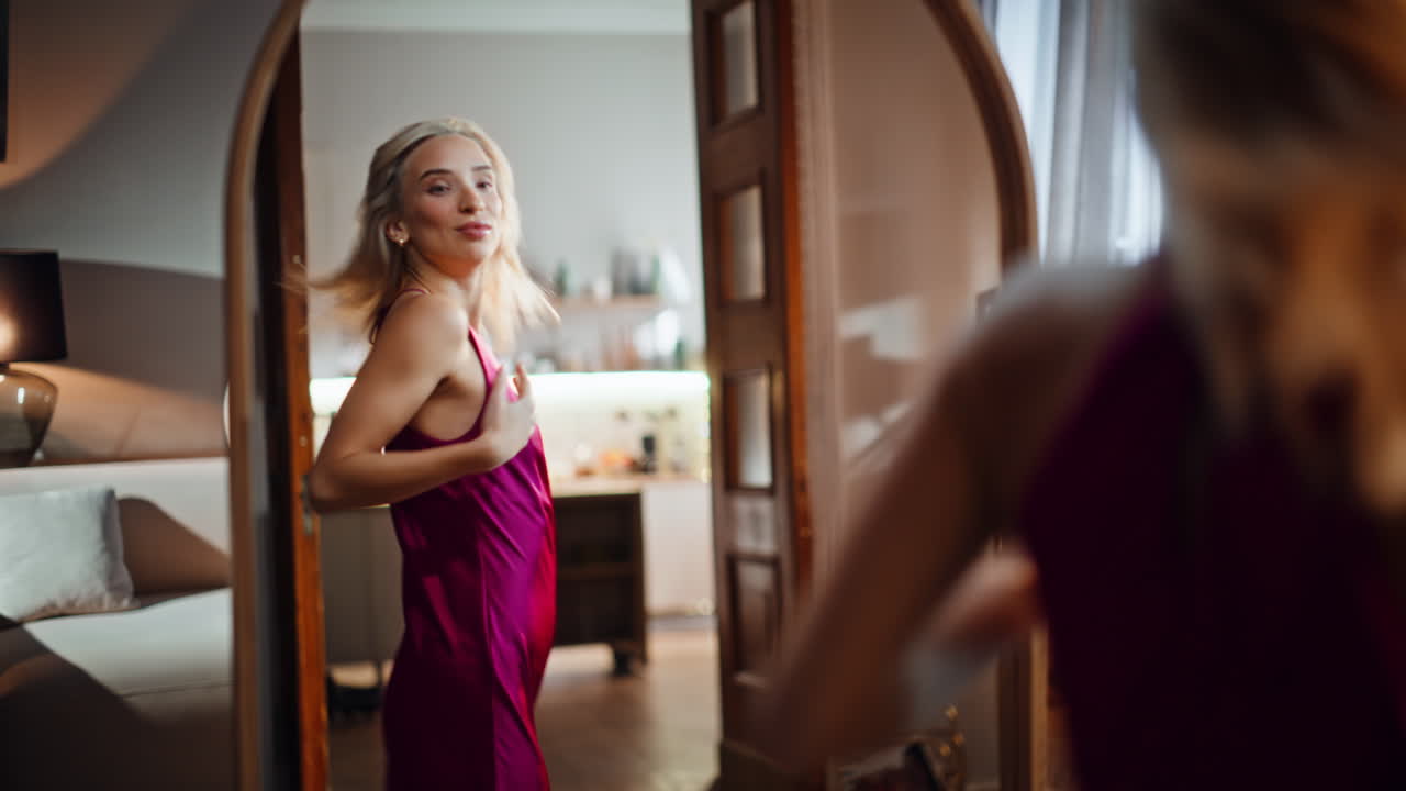 Blonde trying party dress planning outfit gazing reflection. Sexy woman look