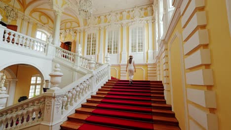 woman climbs ornate staircase, capturing grace and grandeur in soft motion