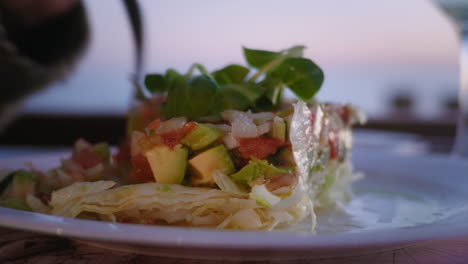 fotografía en primer plano de una ensalada de aguacate en un restaurante al aire libre